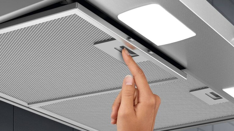 Hand inserting filter in cooker hood